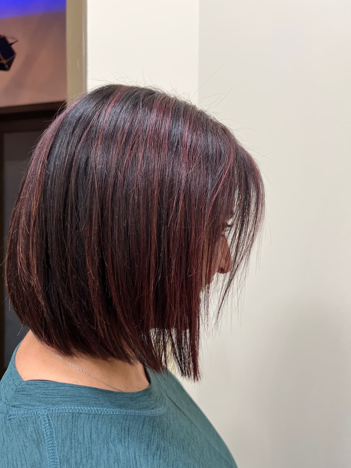 A sharp angled bob in a deep red, cut and finished in the salon
